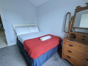 ein Schlafzimmer mit einem Bett und eine Kommode mit einem Spiegel in der Unterkunft Pass the Keys Central 3 Bedroom Home With Free Parking in Birmingham