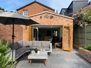 eine Terrasse mit einem Sofa und einem Sonnenschirm in der Unterkunft Pass the Keys Central 3 Bedroom Home With Free Parking in Birmingham