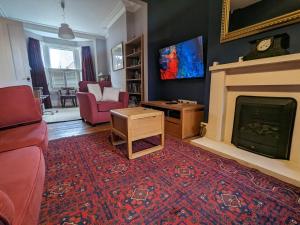 ein Wohnzimmer mit einem Kamin und einem roten Teppich in der Unterkunft Pass the Keys Central 3 Bedroom Home With Free Parking in Birmingham