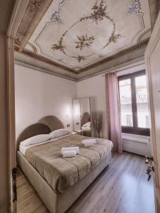 um quarto com uma cama grande e um tecto em Nashira Rooms em Florença