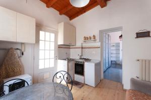 a kitchen with white appliances and a table in a room at Casa liberty style in Milan +8 photos