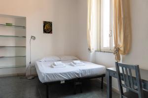 a small bedroom with a bed and a desk and a window at Casa liberty style in Milan
