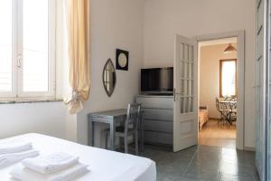 a room with a table and a desk with a television at Casa liberty style in Milan