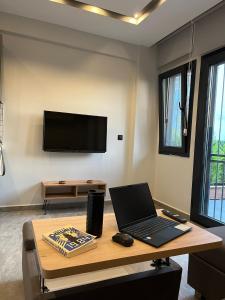 a laptop on a table in a room with a tv at KARAASLAN GROUP TATİL EVLERİ in Kuşadası