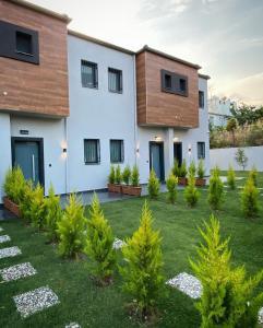 a house with a lawn in front of it at KARAASLAN GROUP TATİL EVLERİ in Kusadası