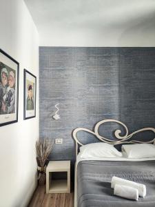 una camera da letto con un letto con una parete grigia di Nashira Rooms a Firenze
