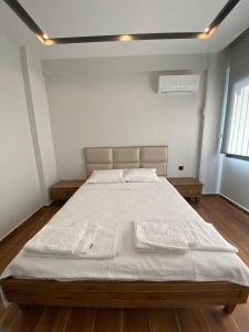 una camera da letto con un grande letto con lenzuola bianche di KARAASLAN GROUP TATİL EVLERİ a Kusadası