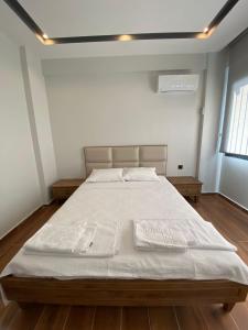 a bedroom with a large bed with white sheets at KARAASLAN GROUP TATİL EVLERİ in Kuşadası