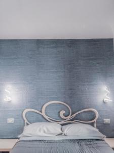 un letto con due luci su una parete blu di Nashira Rooms a Firenze