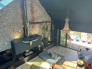 a living room with a couch and a brick wall at Un Loft à la mer : Magnifique maison Batz/Mer in Batz-sur-Mer