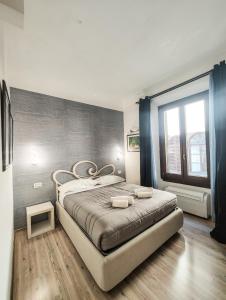 um quarto com uma cama grande e uma janela grande em Nashira Rooms em Florença