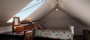 um quarto com uma cama, uma cómoda e uma janela em The Stables em Skibbereen