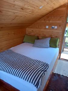 a bed in a cabin with a wooden ceiling at The Bungalows in Sarajevo