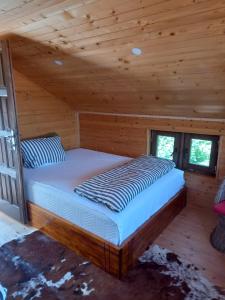a bed in a room with a wooden ceiling at The Bungalows in Sarajevo