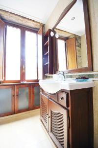 ein Badezimmer mit Waschbecken und Spiegel in der Unterkunft GALIHOST - Casa con precioso jardín en Vilanova de Arousa in Vilanova de Arousa + 25 Fotos