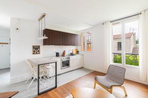 a kitchen with a table and chairs in a room at GuestReady - A minimalist comfort in Vanves in Vanves