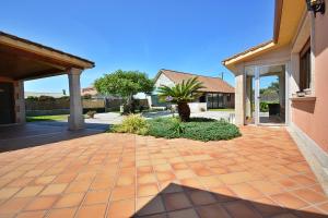 ein Haus mit einer orangefarbenen Backsteineinfahrt in der Unterkunft GALIHOST - Casa con precioso jardín en Vilanova de Arousa in Vilanova de Arousa