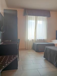 una camera con due letti e una finestra di Hotel Porta Rivera Plesso Stazione a L'Aquila