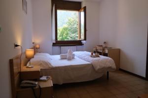 - une chambre avec un grand lit et une fenêtre dans l'établissement Villa Luzzago, à Ponte di Legno