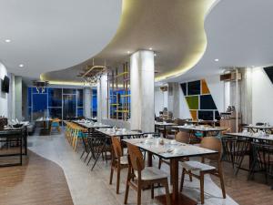 a restaurant with tables and chairs in a room at Harper Banjarmasin in Banjarmasin