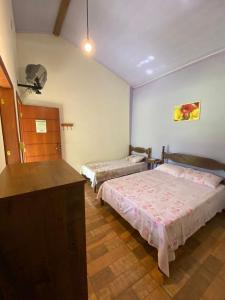 1 dormitorio con 2 camas y vestidor en JACARANDÁ CHALÉS em SÃO JOSÉ DA SERRA MG en Jaboticatubas