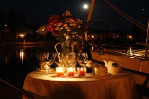 een tafel met glazen en een vaas met bloemen en kaarsen bij Willa Z Widokiem na Jezioro in Ryn
