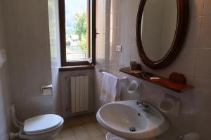 a bathroom with a sink and a toilet and a mirror at Villa Luzzago in Ponte di Legno