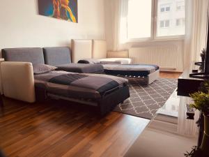 sala de estar con sofá y 2 reposapiés en After Eight Apartment, en Bratislava