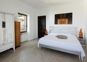 a white bedroom with a bed and a window at Claro De Lua Circeo B&B in San Felice Circeo