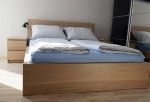 a bed with a wooden frame in a bedroom at Apartament Amerigo in Wrocław