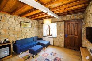 a living room with a blue couch and a stone wall at Dedeman Van Resort & Aquapark in Van