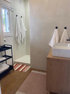 a bathroom with a sink and a shower with towels at Casa Limonero in Sedella