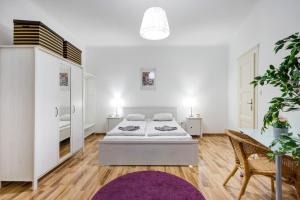 ブダペストにあるJulie's flatの白いベッドルーム(ベッド1台、紫の敷物付)