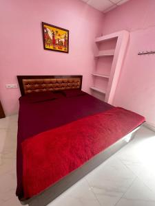 a bedroom with a bed with a red blanket at Hotel Tathastu in Rāmtek