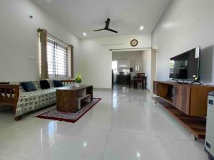 a living room with a couch and a flat screen tv at SSN Home Stays in Bangalore near PLAY Arena in Bangalore