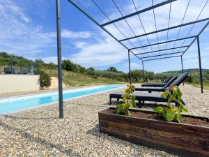 una piscina con 2 tumbonas y una pérgola en Villa 4 étoiles avec 2 chambres climatisation et piscine privée, en Vagnas