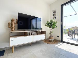 una sala de estar con TV de pantalla plana en un armario blanco en Villa 4 étoiles avec 2 chambres climatisation et piscine privée, en Vagnas