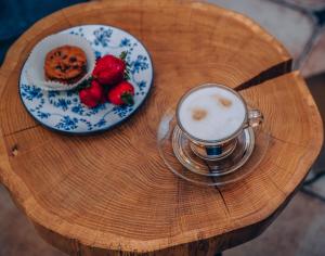 una mesa con una taza de café y un plato de fresas en Willa Skalniak, en Lądek-Zdrój