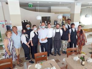 a group of people posing for a picture in a kitchen at Hotel La Residenza in Riccione