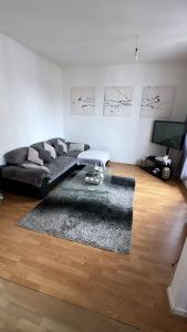 a living room with a black couch and a rug at Appartement 60 m², porte de Saint-Cloud in Boulogne-Billancourt