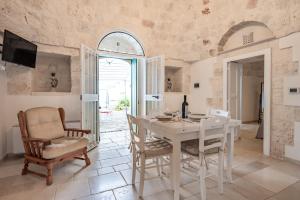 a dining room with a white table and chairs at Trullo Suite in Masseria in Cisternino
