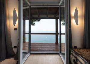 una puerta abierta a un balcón con vistas al océano en Claro De Lua Circeo B&B en San Felice Circeo