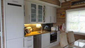 una cocina con armarios blancos y fregadero en Perla, en Stryn