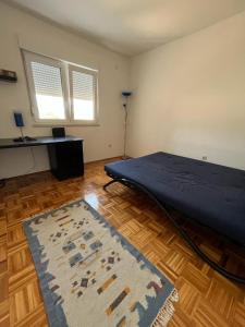 um quarto com uma cama e um tapete num piso de madeira em Apartment Darna em Neum