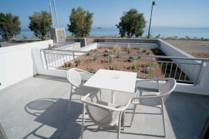a table and chairs on a balcony with the ocean at Agistri Beach in Skala