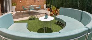 un jardín en miniatura con sillas azules y una mesa en Casa MIMAR - moderna, jardín y wifi fibra 1 GB, ideal para vacaciones y teletrabajo, en La Oliva