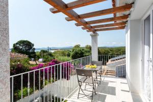 a balcony with chairs and a table on a building at Sardegna è - New Rooms in Olbia
