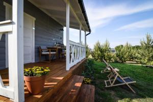 a porch of a house with a table and chairs at Pogodny domek in Kołczewo