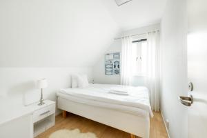 a white bedroom with a bed and a window at Österlens Golfklubb - Lilla Vik in Simrishamn
