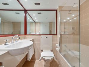 a bathroom with a sink and a toilet and a shower at Thredbo Alpine Hotel in Thredbo